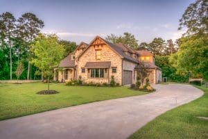 A beautiful home sits at the end of its driveway, lit by the afternoon sun.