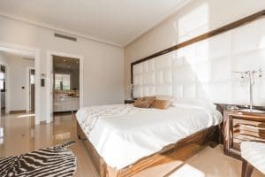 modern bedroom with zebra carpet and king-sized bed with fresh, white linen