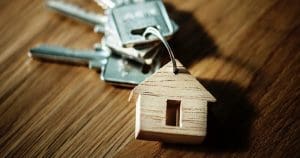 wooden house keychain with four keys on it