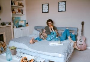 Couple eats pizza in bed