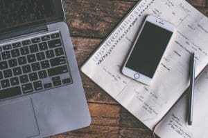 Computer, notebook, and phone on a desk